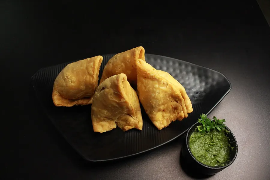 Golden samosas with green chutney